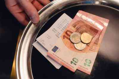Silbernes Tablett mit Trinkgeld und Rechnung darauf - © Medienzunft Berlin - Adobe Stock.com